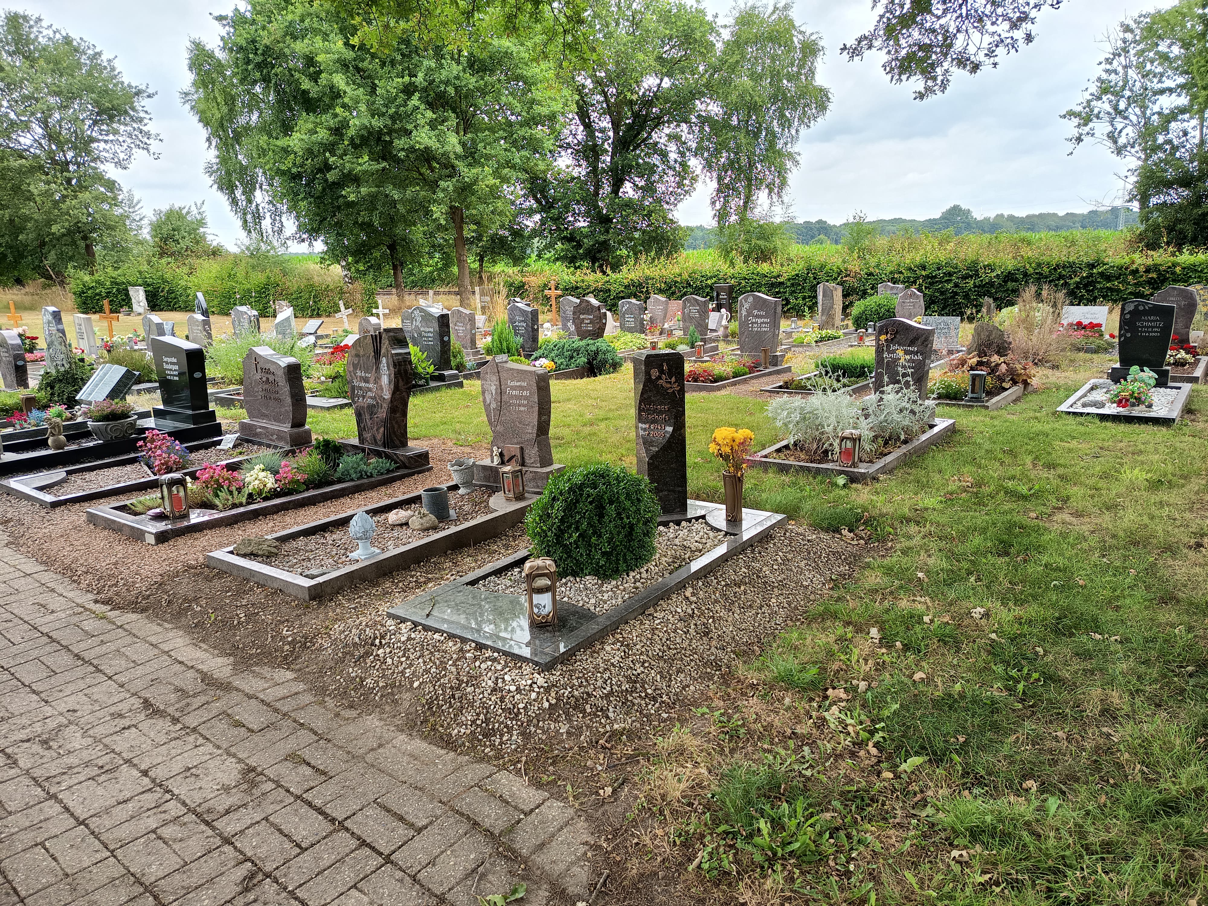 Gepflegter Friedhof mit Grabsteinen und Bepflanzung